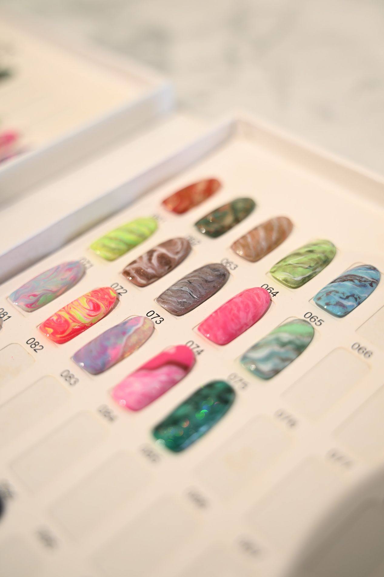 Voorbeeldtips met nailart ontwerpen in een doosje