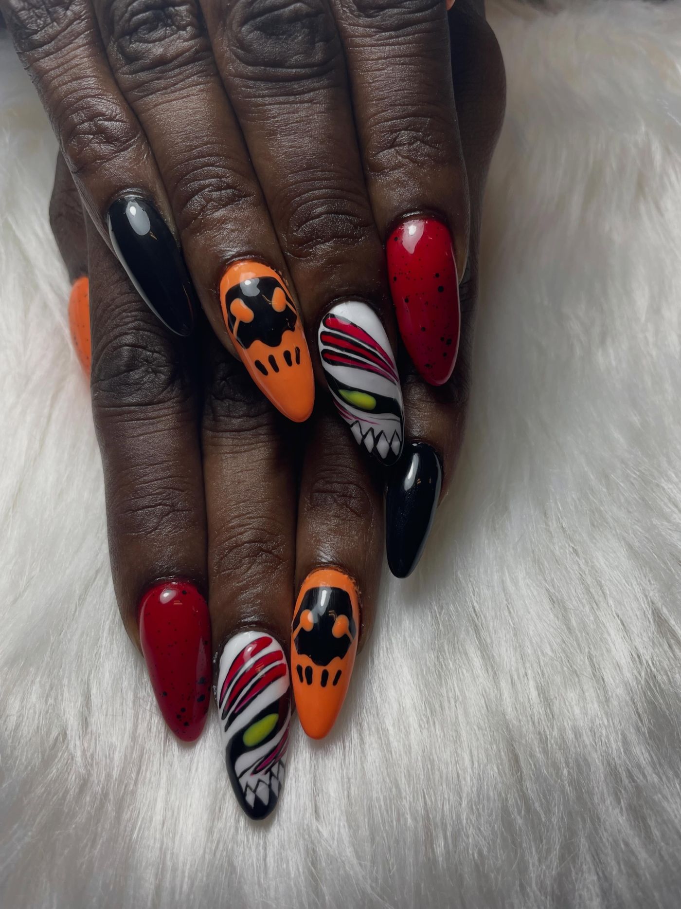 Nailart in zwart, oranje en rood op lange amandelnagels